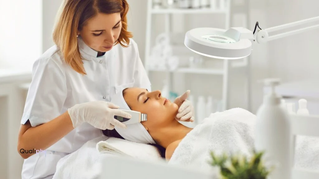 A licensed med spa provider performing a facial assessment on a patient during a Good Faith Exam in a clean, professional aesthetic treatment room.