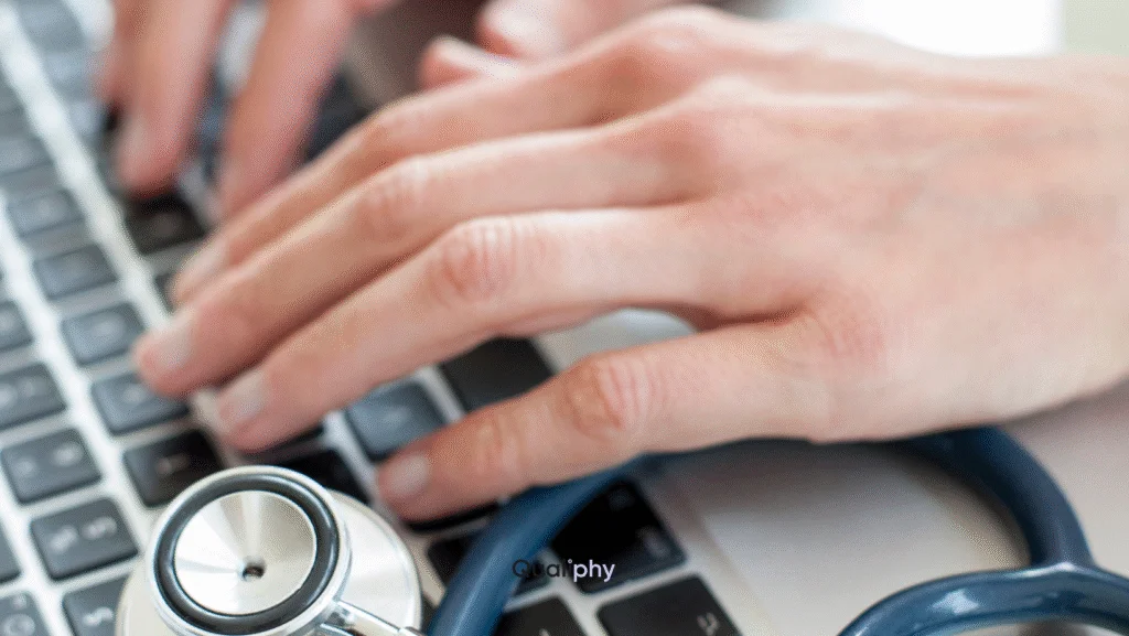 Healthcare provider typing on a laptop with stethoscope nearby during a Good Faith Exam and Patient-Specific Order via telemedicine.