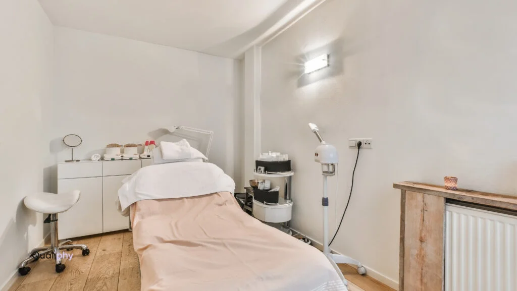 Modern med spa treatment room with clean white walls, skincare equipment, and a comfortable exam bed—ideal for delivering custom treatment plans through personalized aesthetic and wellness care.
