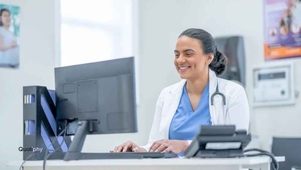 Smiling licensed provider conducting a virtual consultation from a medical office, supporting med spa risk management through compliant patient-specific orders using telehealth.